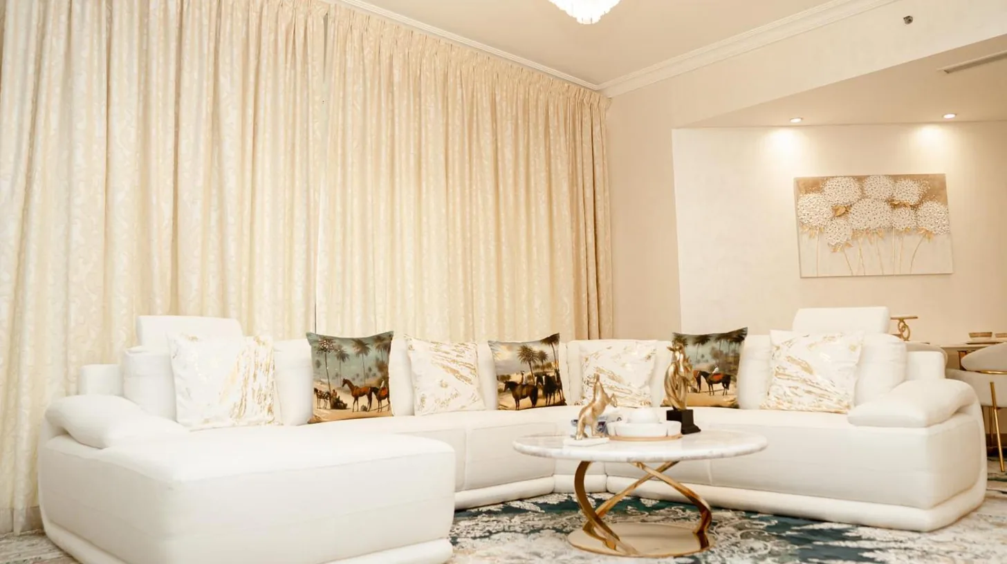 una sala de estar con dos sofÃ¡s blancos y una mesa en 2BDR Luxury Apartment in Palm en DubÃ¡i