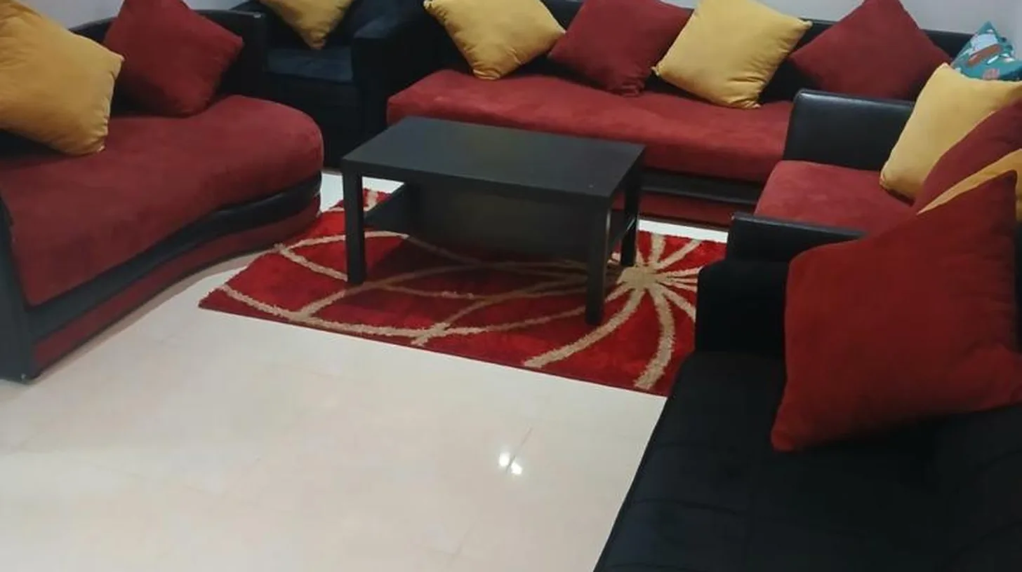 a living room with red and black couches at تجزئة الفتح 925 خريبكة 4 in Khouribga