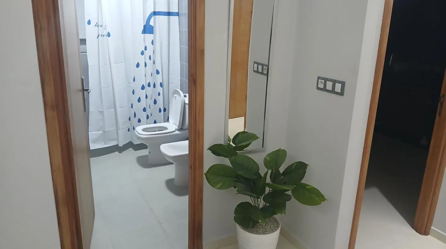 a bathroom with a toilet and a potted plant at تجزئة الفتح 925 خريبكة 4 in Khouribga
