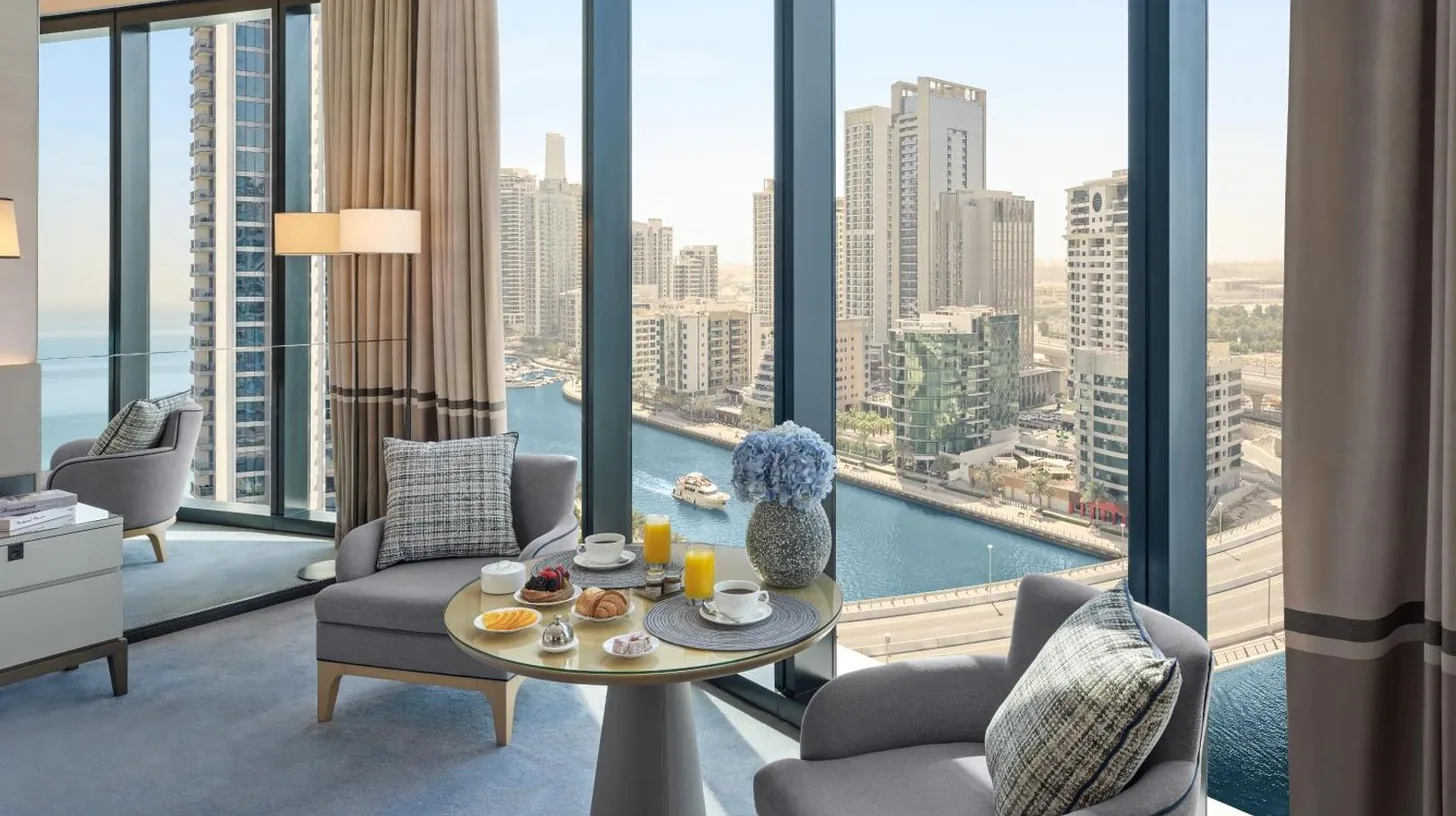un salon avec une table et des chaises et une grande fenÃªtre Ã  l'Address Beach Resort Ã  DubaÃ¯