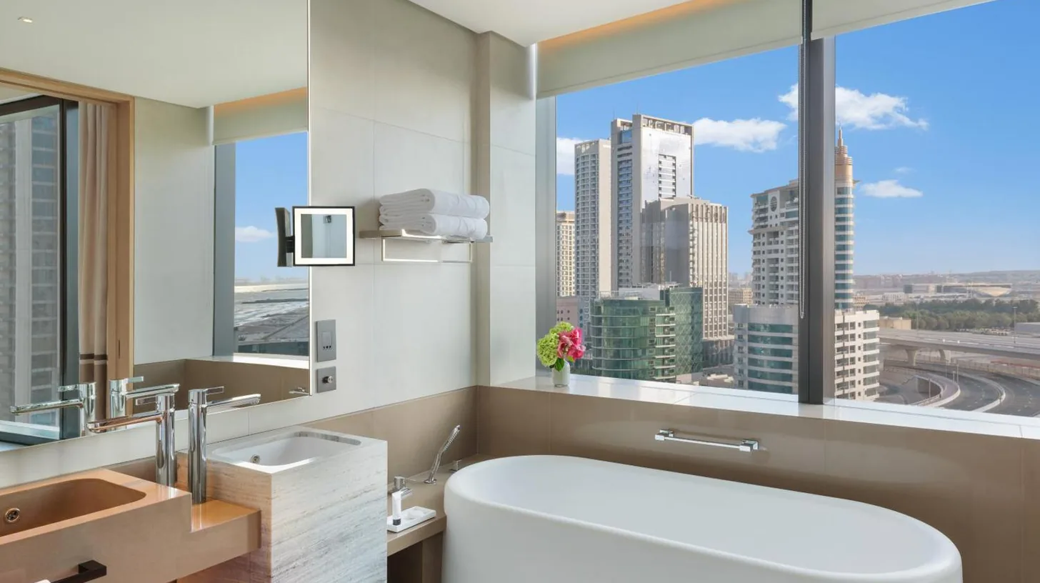 une salle de bains avec une grande baignoire blanche et une grande fenÃªtre Ã  l'Address Beach Resort Ã  DubaÃ¯