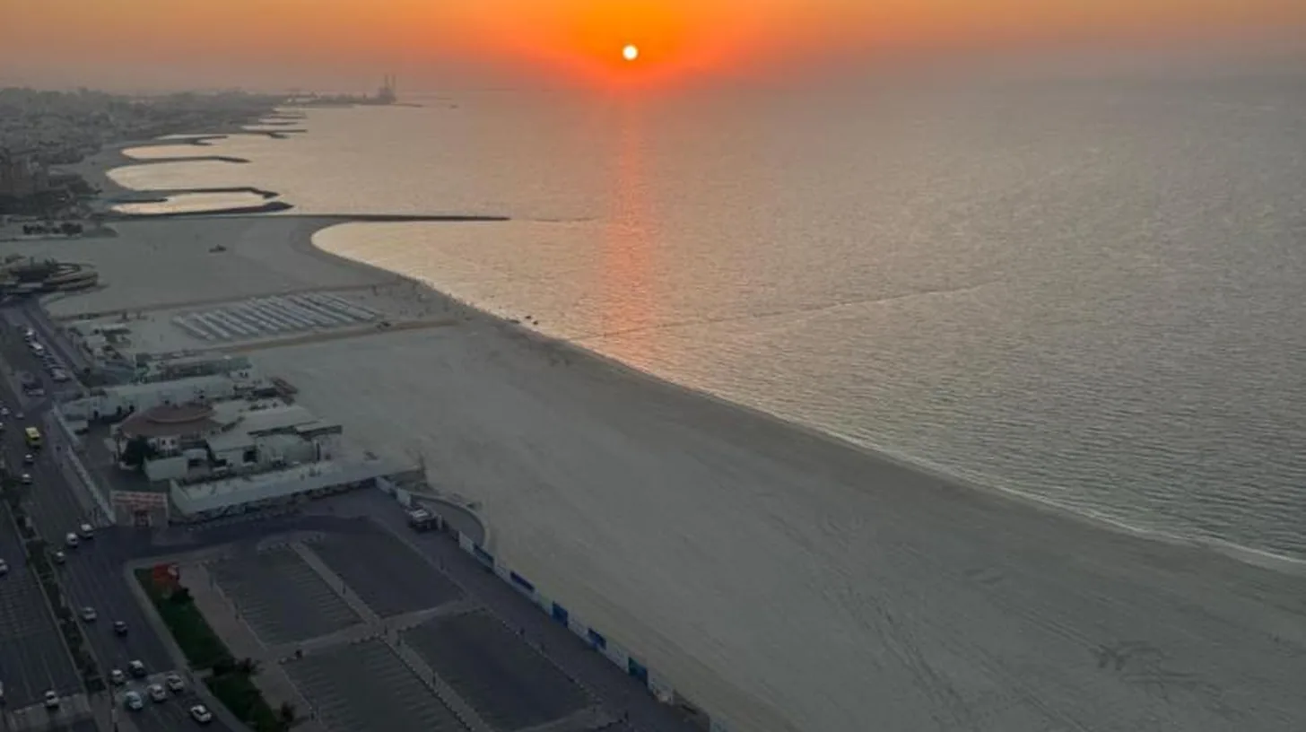 una vista aérea de la playa al atardecer en Ajman Luxurious Holiday Homes en Ajman