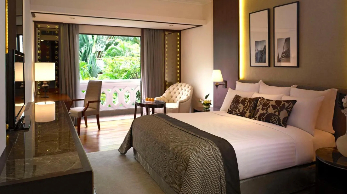 une chambre avec un grand lit et un salon Ã  l'Anantara Riverside Bangkok Resort Ã  Bangkok