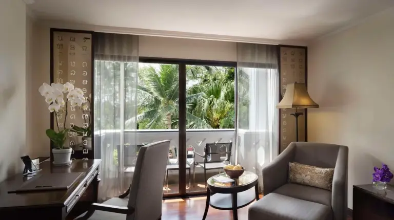 un salon avec un bureau, une table et des chaises Ã  l'Anantara Riverside Bangkok Resort Ã  Bangkok