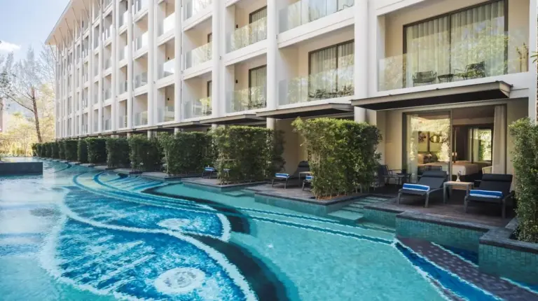 a swimming pool in front of a building at Avani Plus Khao Lak Resort in Khao Lak
