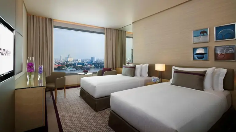 una habitaciÃ³n de hotel con dos camas y una ventana grande en Avani Plus Riverside Bangkok Hotel en Bangkok