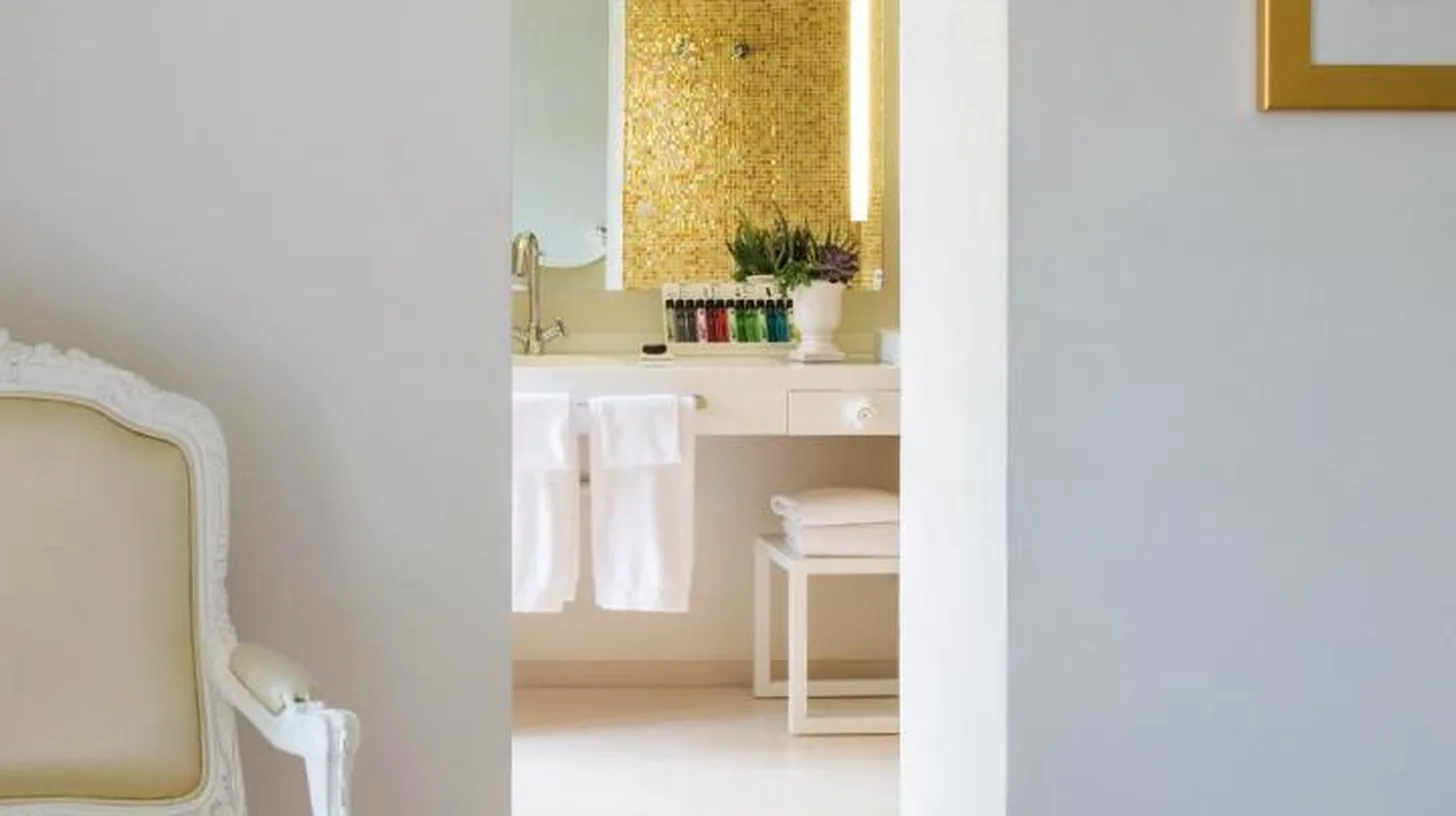 a white chair in a room with a bathroom at Boscolo Nice Hotel & Spa in Nice