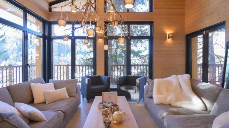 un salón con un sofá y una mesa en Chalet avec Piscine La Plagne en La Plagne Tarentaise