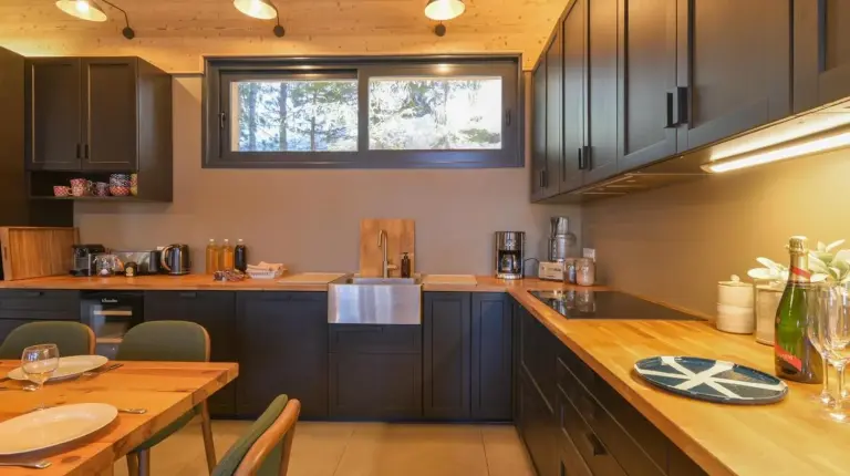 a kitchen with wooden cabinets and a wooden table at Chalet avec Piscine La Plagne in La Plagne Tarentaise