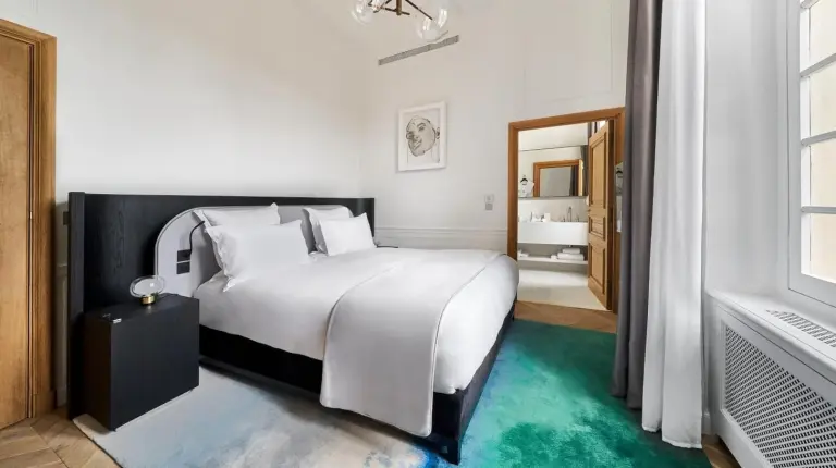 a bedroom with a white bed and a green carpet at Château de la Gaude in Aix-en-Provence