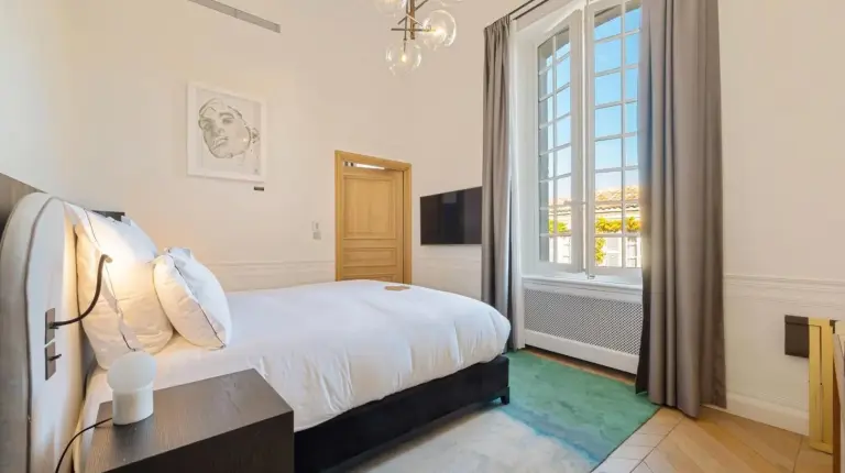 a bedroom with a bed and a large window at Château de la Gaude in Aix-en-Provence