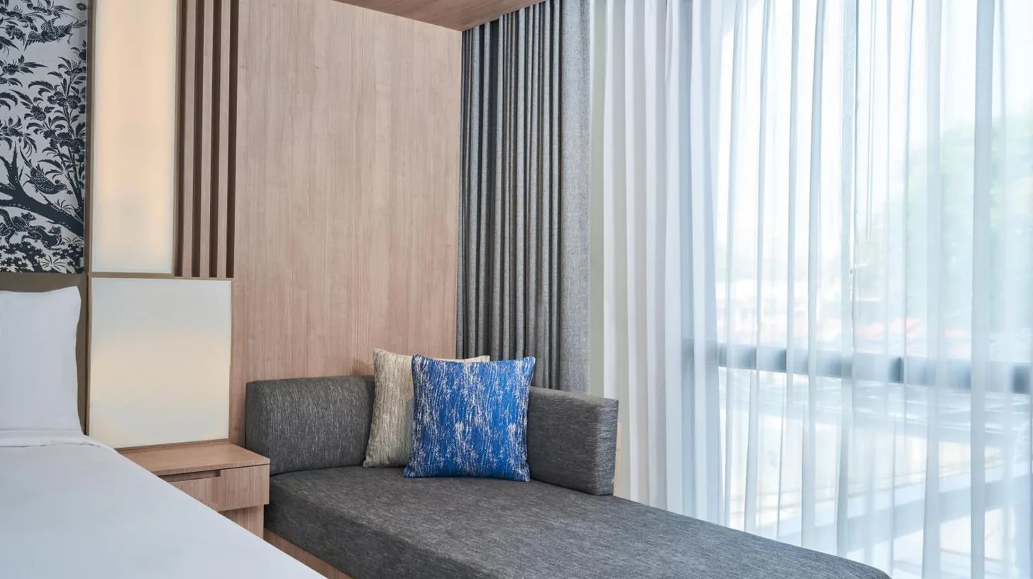 a bedroom with a couch and a window at Courtyard by Marriott North Pattaya in Pattaya North
