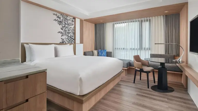a hotel room with a large bed and a desk at Courtyard by Marriott North Pattaya in Pattaya North