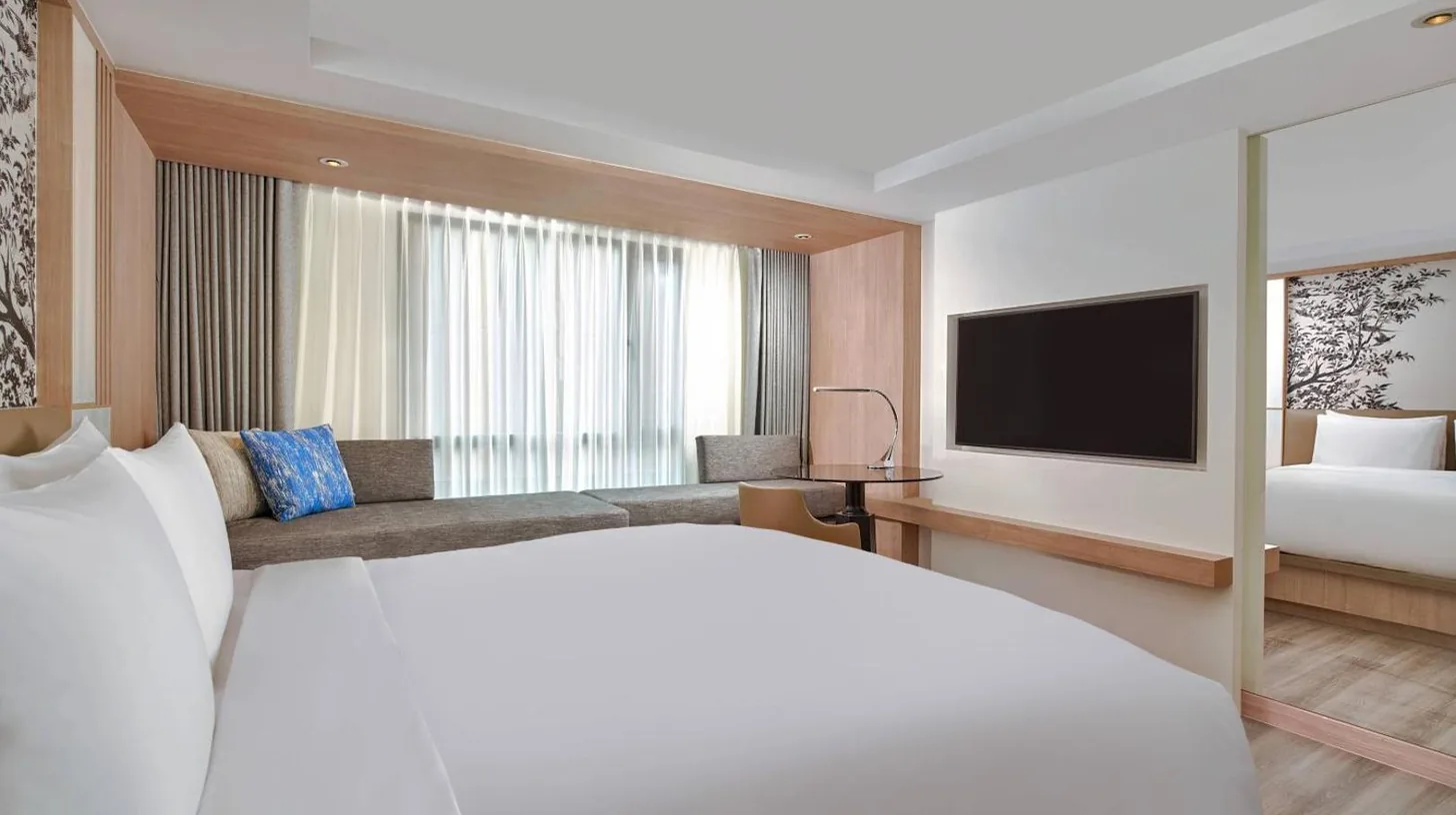 a hotel room with a bed and a television at Courtyard by Marriott North Pattaya in Pattaya North