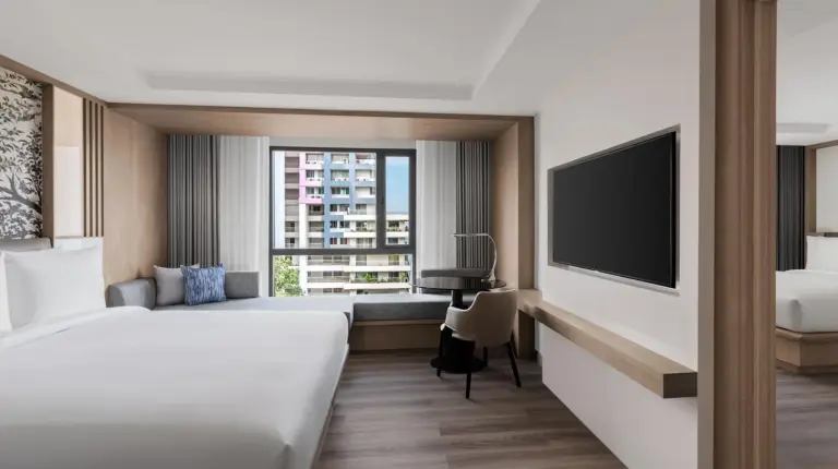 a hotel room with a bed and a flat screen tv at Courtyard by Marriott North Pattaya in Pattaya North
