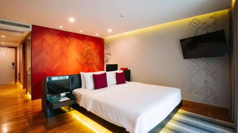 un dormitorio con una cama y un televisor de pantalla plana en Cross Chiang Mai Riverside en Chiang Mai