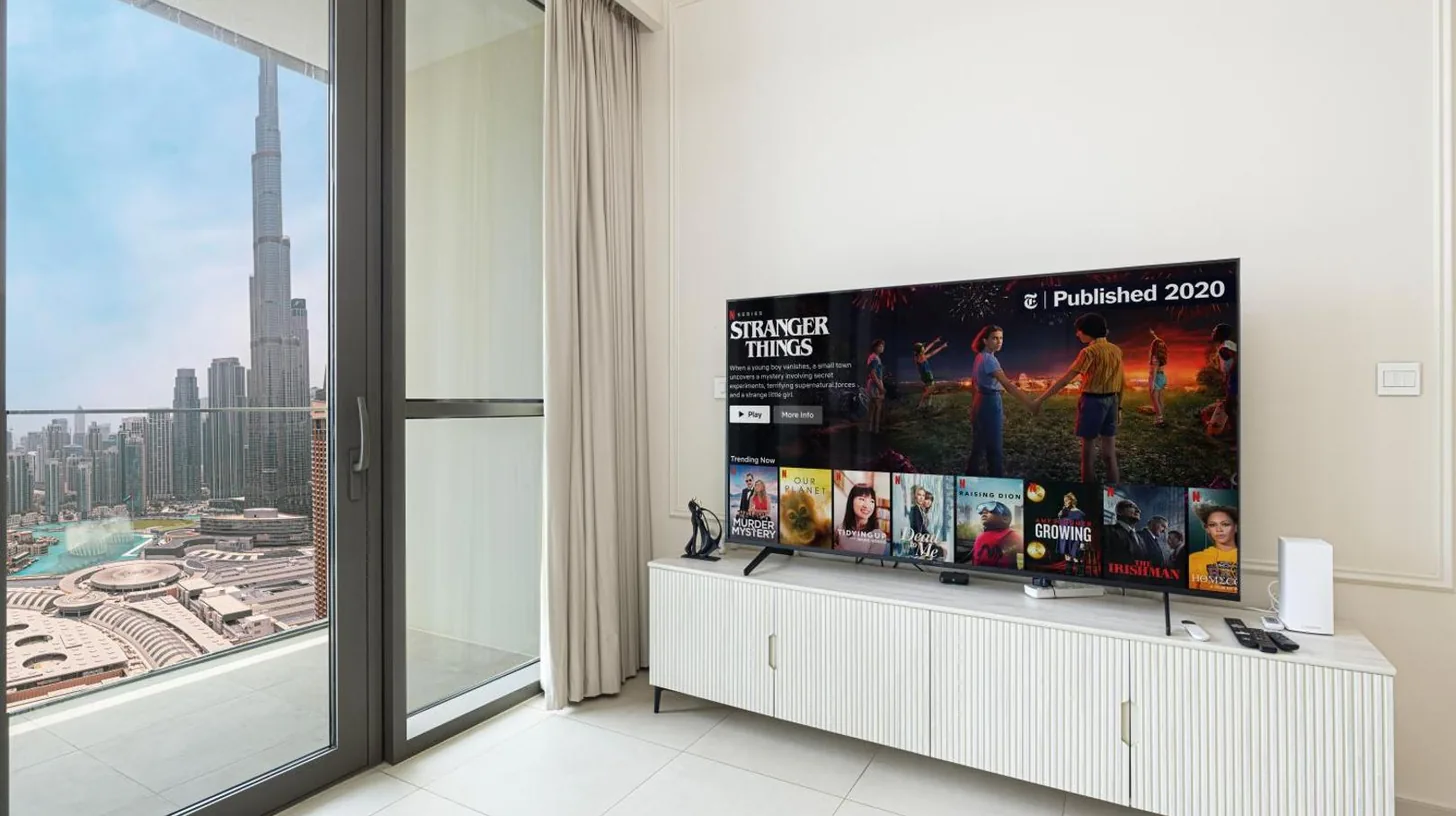 a living room with a large window and a flat screen tv at Downtown 4 BR- 1 minute Burj Khalifa & Dubai Mall in Dubai