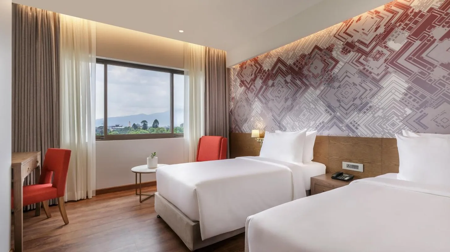 una habitaciÃ³n de hotel con dos camas y una ventana en Dusit Princess Kathmandu en KatmandÃº