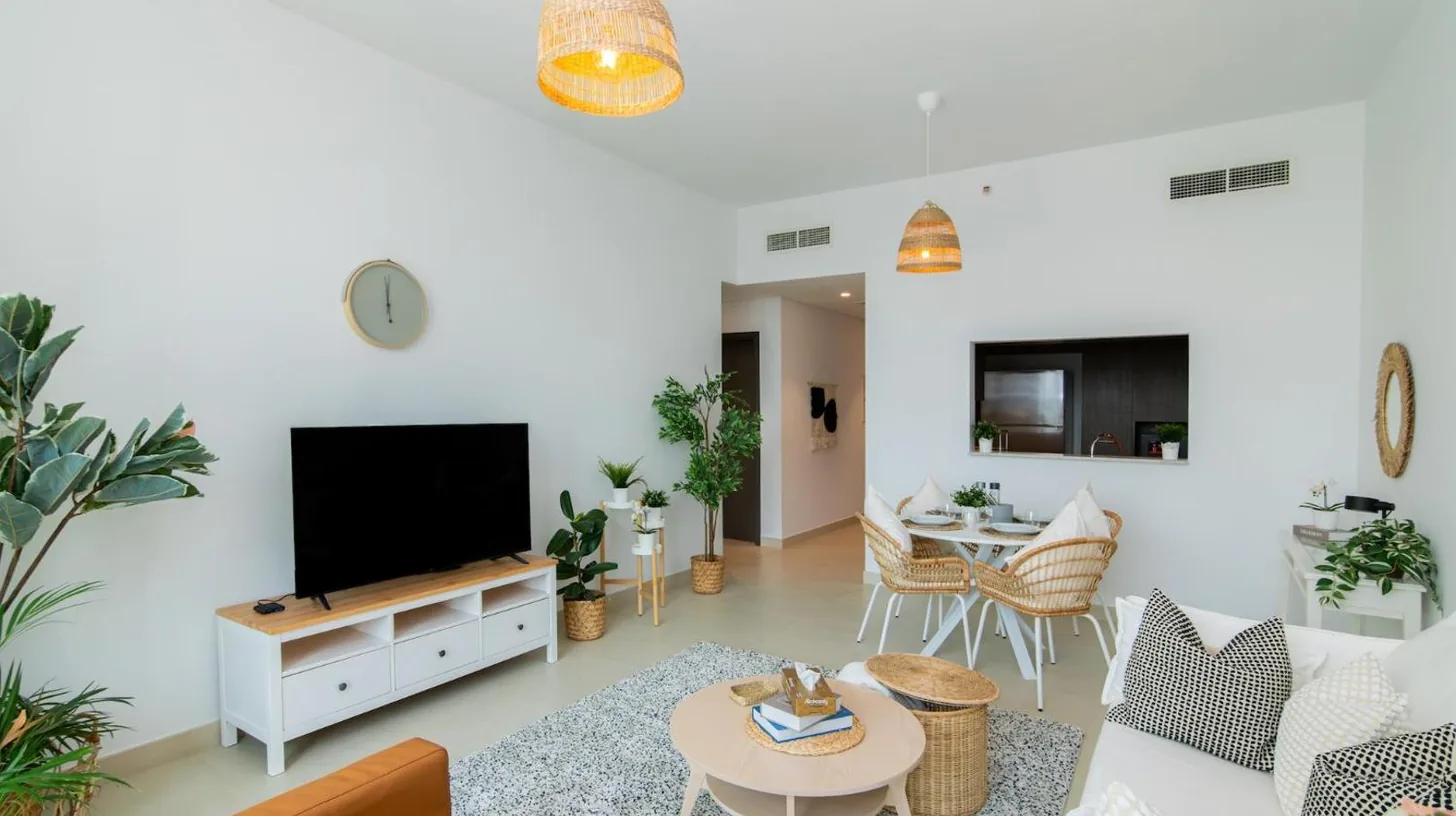 a living room with a couch and a tv at Elite Escape Holiday Home - 2 BHK Getaway with Dubai Mall Access - 1508 in Dubai