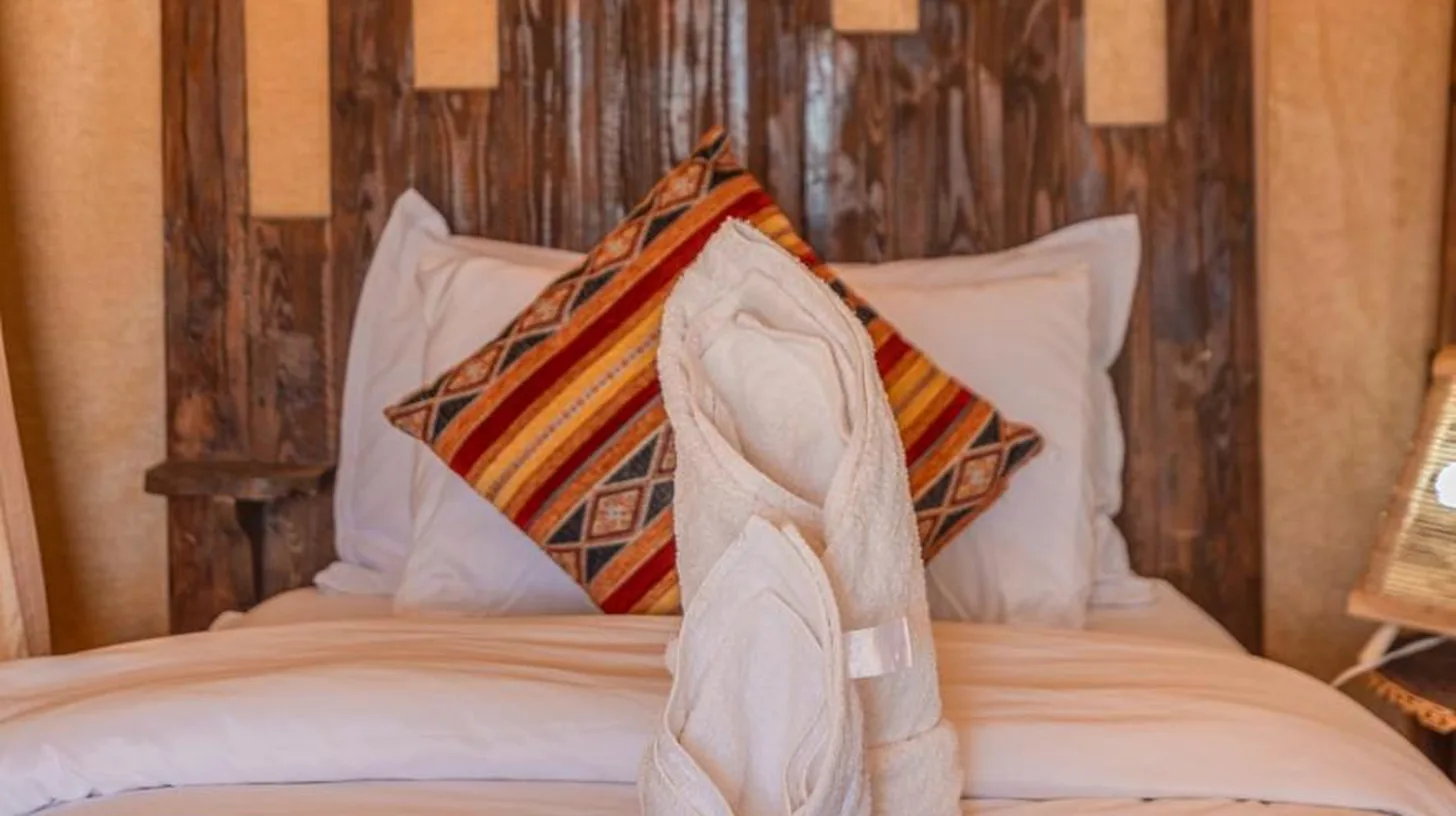 a hotel room with a bed with towels on it at Enjoy Luxury Camp in Merzouga