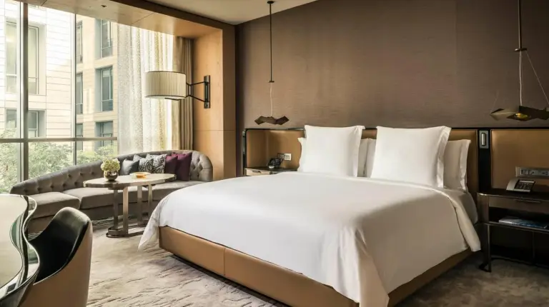 ein Schlafzimmer mit einem groÃen weiÃen Bett und einem Sofa im Four Seasons Hotel Dubai International Financial Centre in Dubai