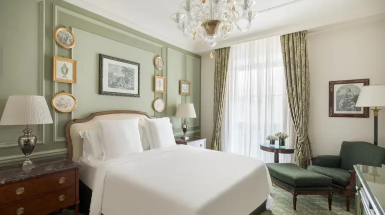 a bedroom with a white bed and a chandelier at Four Seasons Hotel Firenze in Florence