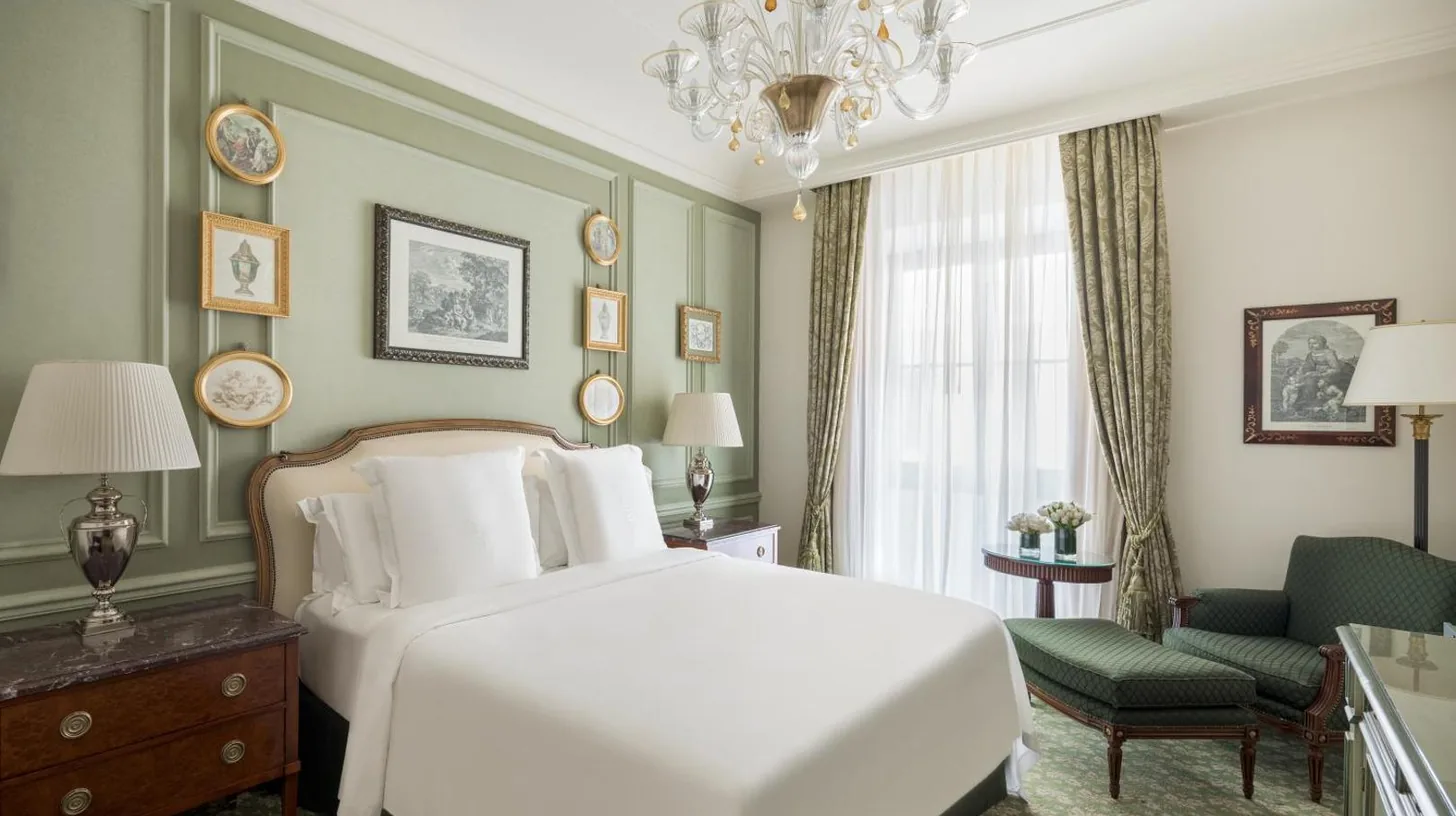 a bedroom with a white bed and a chandelier at Four Seasons Hotel Firenze in Florence