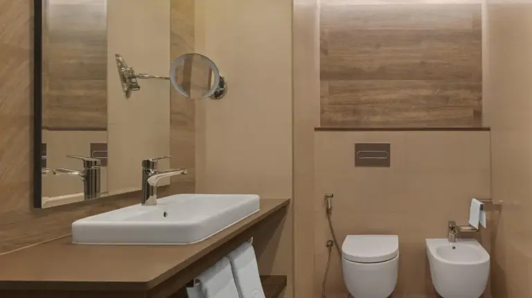 a bathroom with a sink and a toilet at Fujairah Rotana Resort & Spa - Al Aqah Beach in Al Aqah