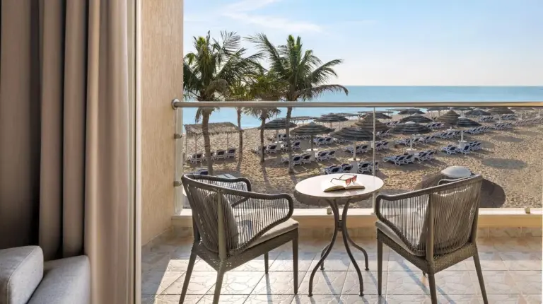 a balcony with a table and chairs and the beach at Fujairah Rotana Resort & Spa - Al Aqah Beach in Al Aqah
