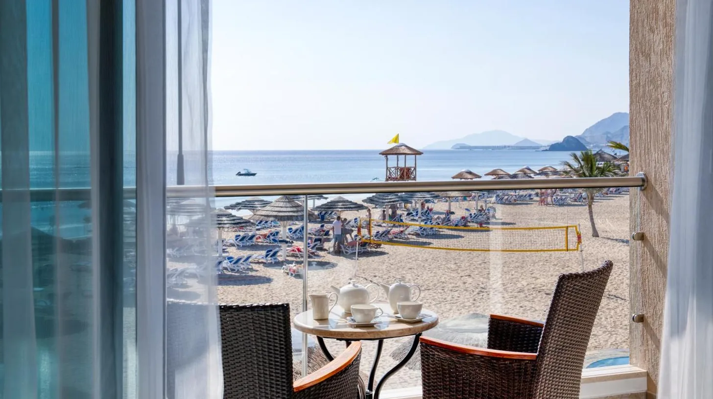 a view of the beach from the balcony of a resort at Fujairah Rotana Resort & Spa - Al Aqah Beach in Al Aqah
