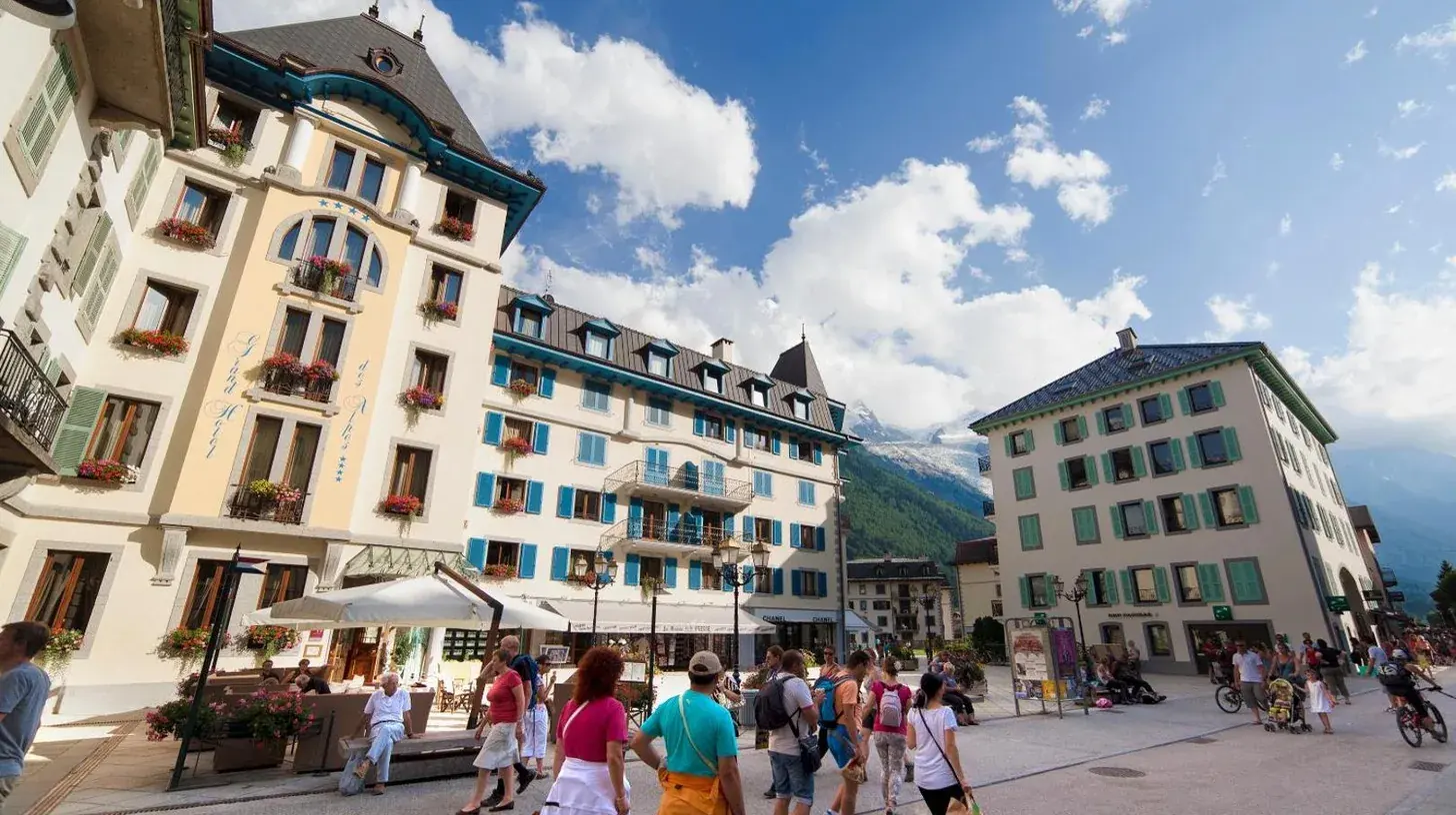 ein Schlafzimmer mit einem groÃen Bett und einem Schreibtisch im Grand HÃ´tel des Alpes in Chamonix-Mont-Blanc