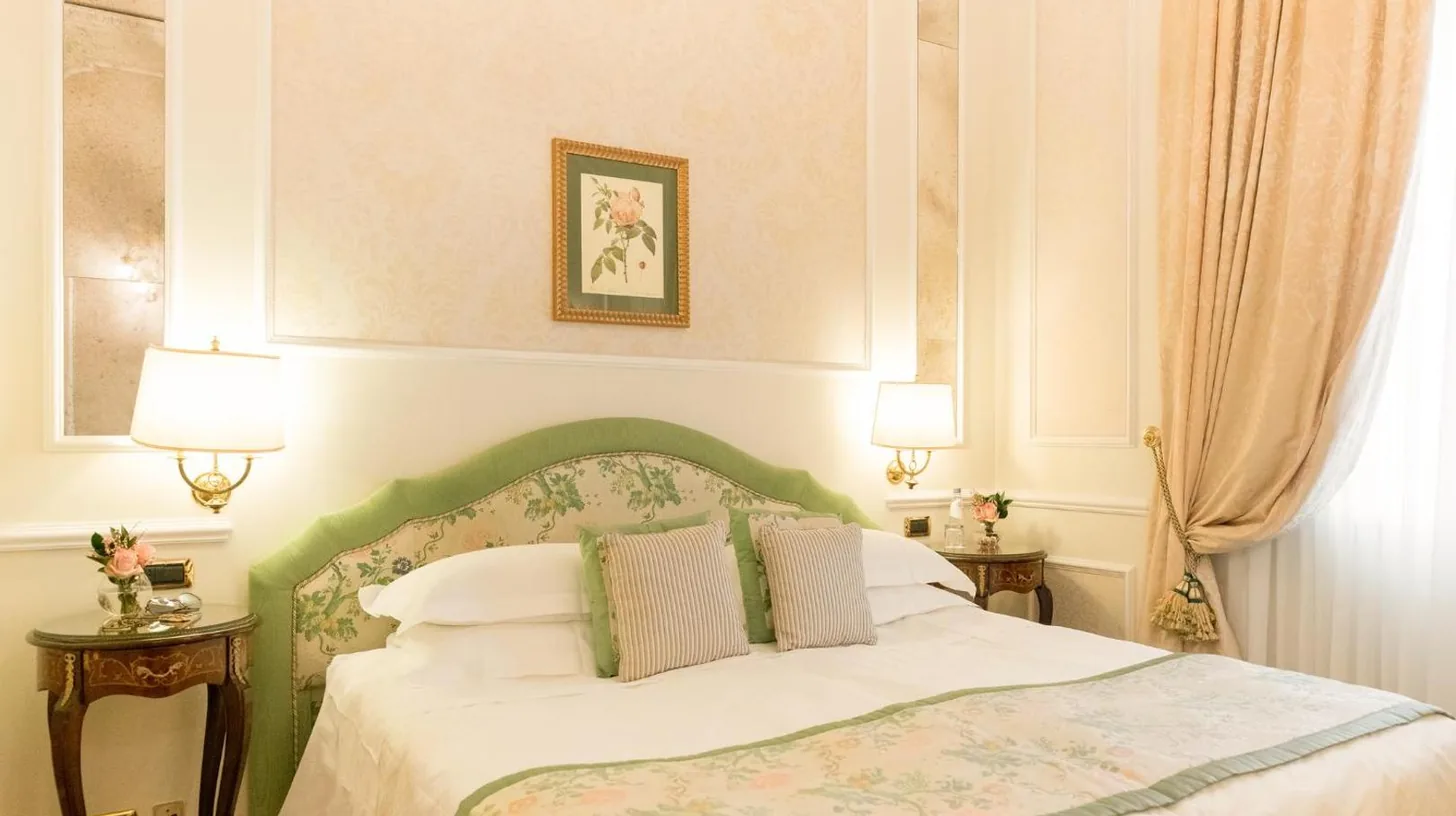 une chambre avec un lit, deux tables et deux lampes au Grand Hotel Majestic gia' Baglioni à Bologne