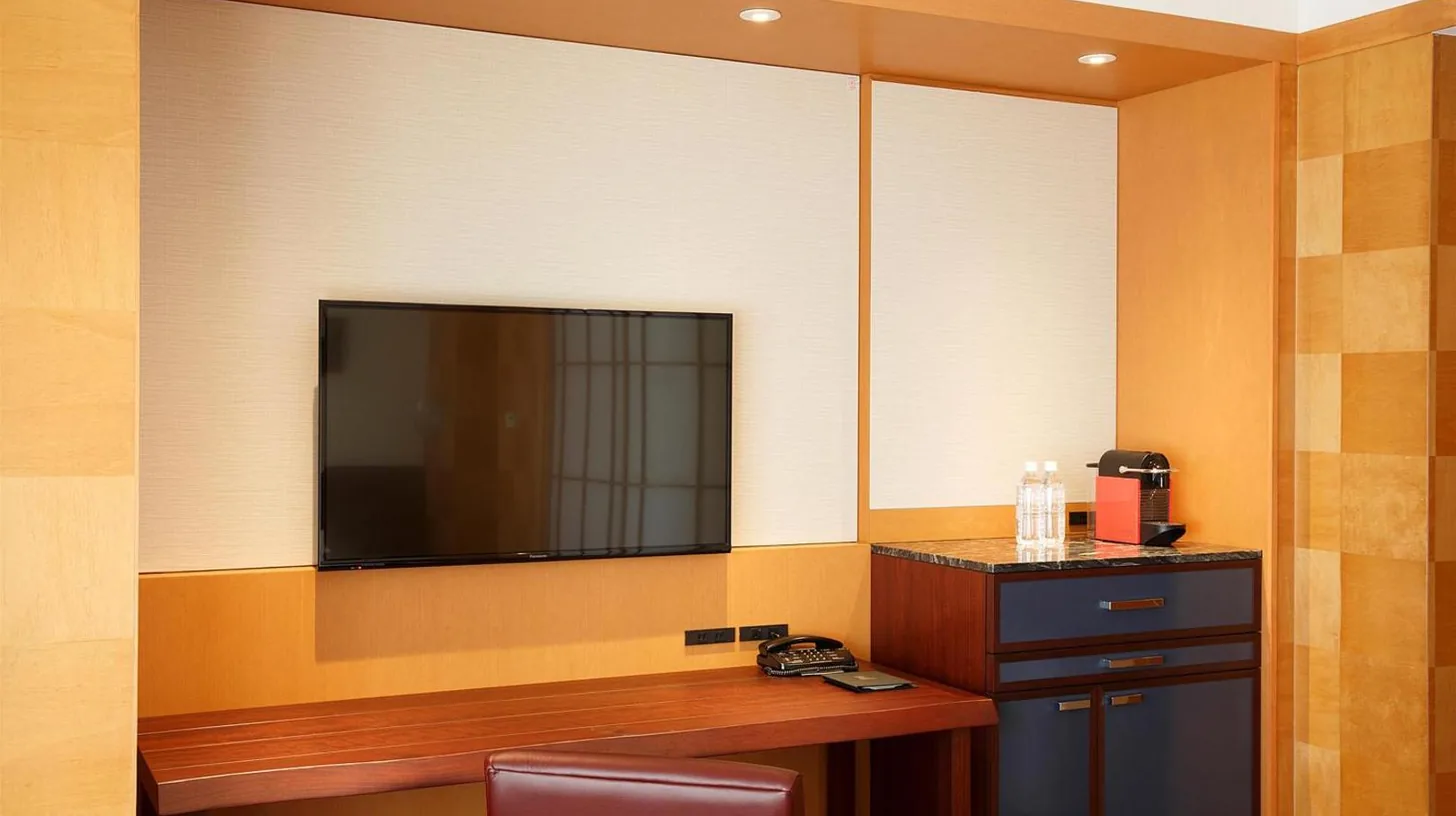 una habitaciÃ³n con un escritorio y una televisiÃ³n en la pared en Grand Hyatt Fukuoka en Fukuoka
