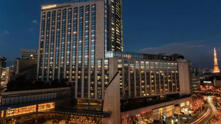 a large building with lights on in a city at night at Grand Hyatt Tokyo in Tokyo