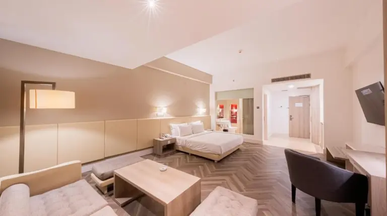 a large living room with a bed and a couch at Grand Jatra Hotel Balikpapan in Balikpapan