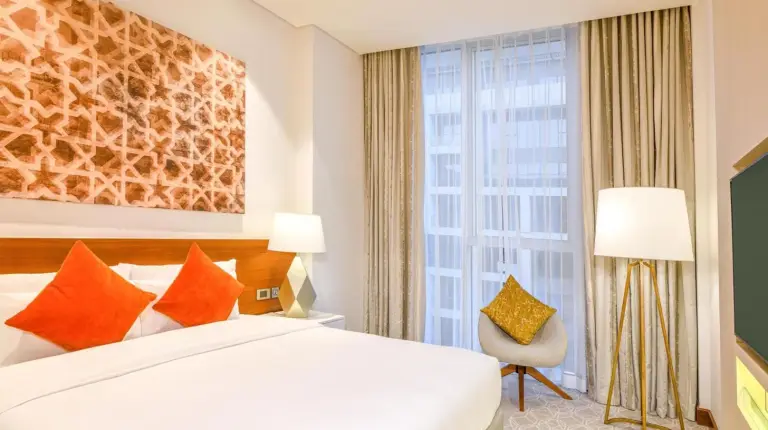 ein Schlafzimmer mit einem groÃen weiÃen Bett mit Kissen im Grand Mercure Dubai City in Dubai