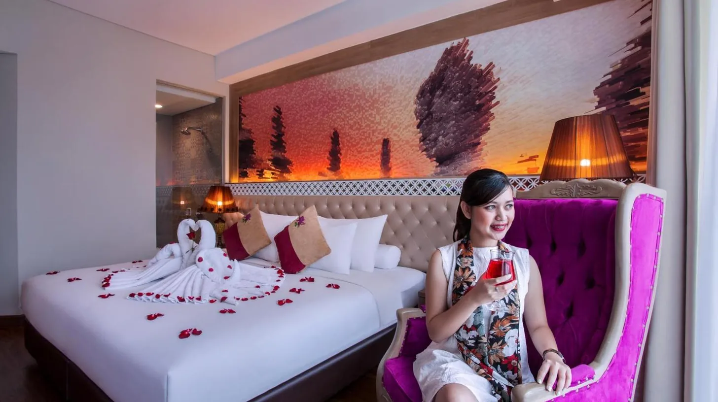 ein Hotelzimmer mit einem großen weißen Bett und einem Fenster im Grand Mercure Yogyakarta Adi Sucipto in Yogyakarta