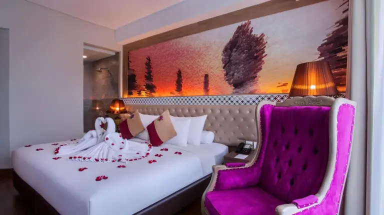 ein Hotelzimmer mit zwei Betten und einem Tisch mit Stühlen im Grand Mercure Yogyakarta Adi Sucipto in Yogyakarta