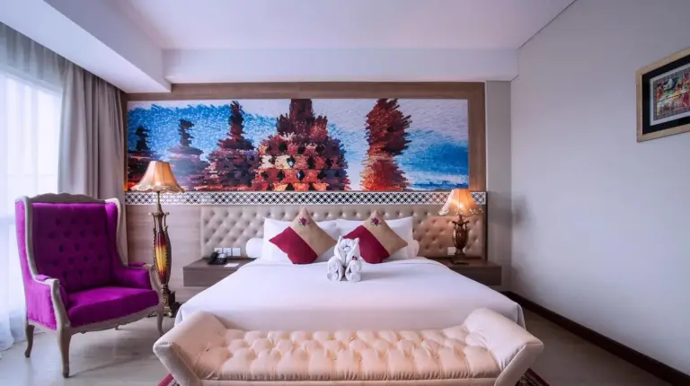 ein Schlafzimmer mit einem großen Bett und einem Fernseher im Grand Mercure Yogyakarta Adi Sucipto in Yogyakarta