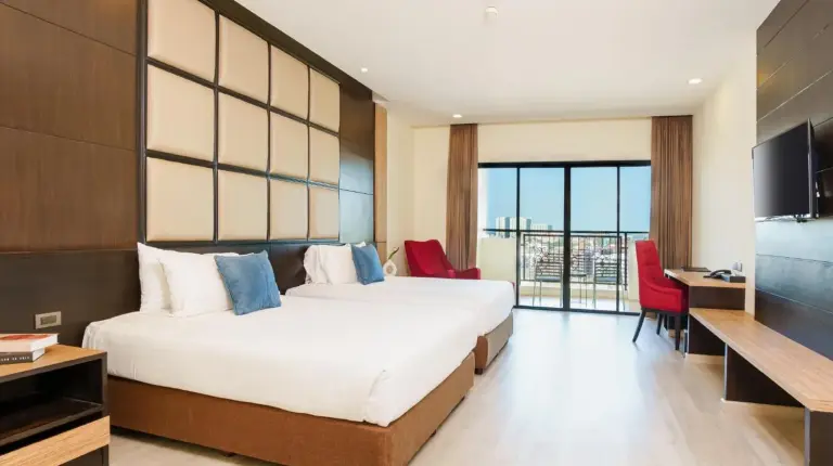 una habitaciÃ³n de hotel con una cama grande y una televisiÃ³n en Grand Palazzo Hotel - SHA Extra Plus en Pattaya Central