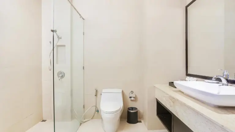 un baÃ±o con un inodoro, un lavabo y un espejo en Grand Palazzo Hotel - SHA Extra Plus en Pattaya Central