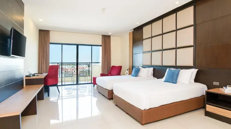una habitaciÃ³n de hotel con dos camas y una televisiÃ³n en Grand Palazzo Hotel - SHA Extra Plus en Pattaya Central