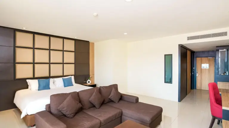 una sala de estar con un sofÃ¡ y una cama en Grand Palazzo Hotel - SHA Extra Plus en Pattaya Central