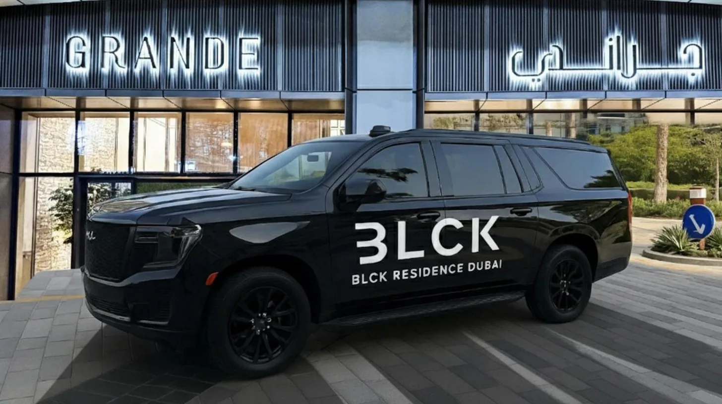 ein schwarzer SUV, geparkt vor einem Gebäude bei GRANDE RESIDENCES mit direktem Burj Khalifa‑Blick und privater Springbrunnenshow im 62. Stockwerk mit DXB AIRPORT VIP Shuttle‑Option für 8 Gäste in Dubai