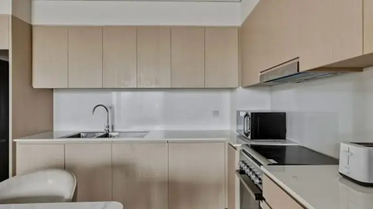 une cuisine avec Ã©vier et cuisiniÃ¨re Ã  Grande Signature Residences Ã  DubaÃ¯