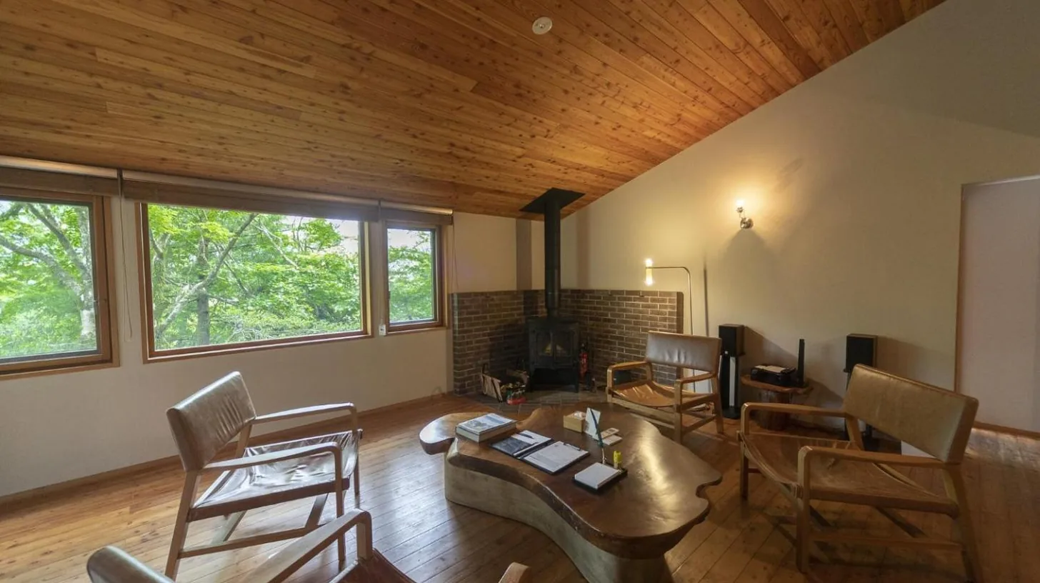 un salon avec un canapÃ© et une table avec des chaises Ã  Hakone Retreat villa 1/f Ã  Hakone