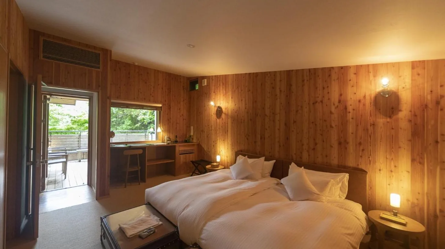 une chambre avec un grand lit dans un mur en bois Ã  Hakone Retreat villa 1/f Ã  Hakone