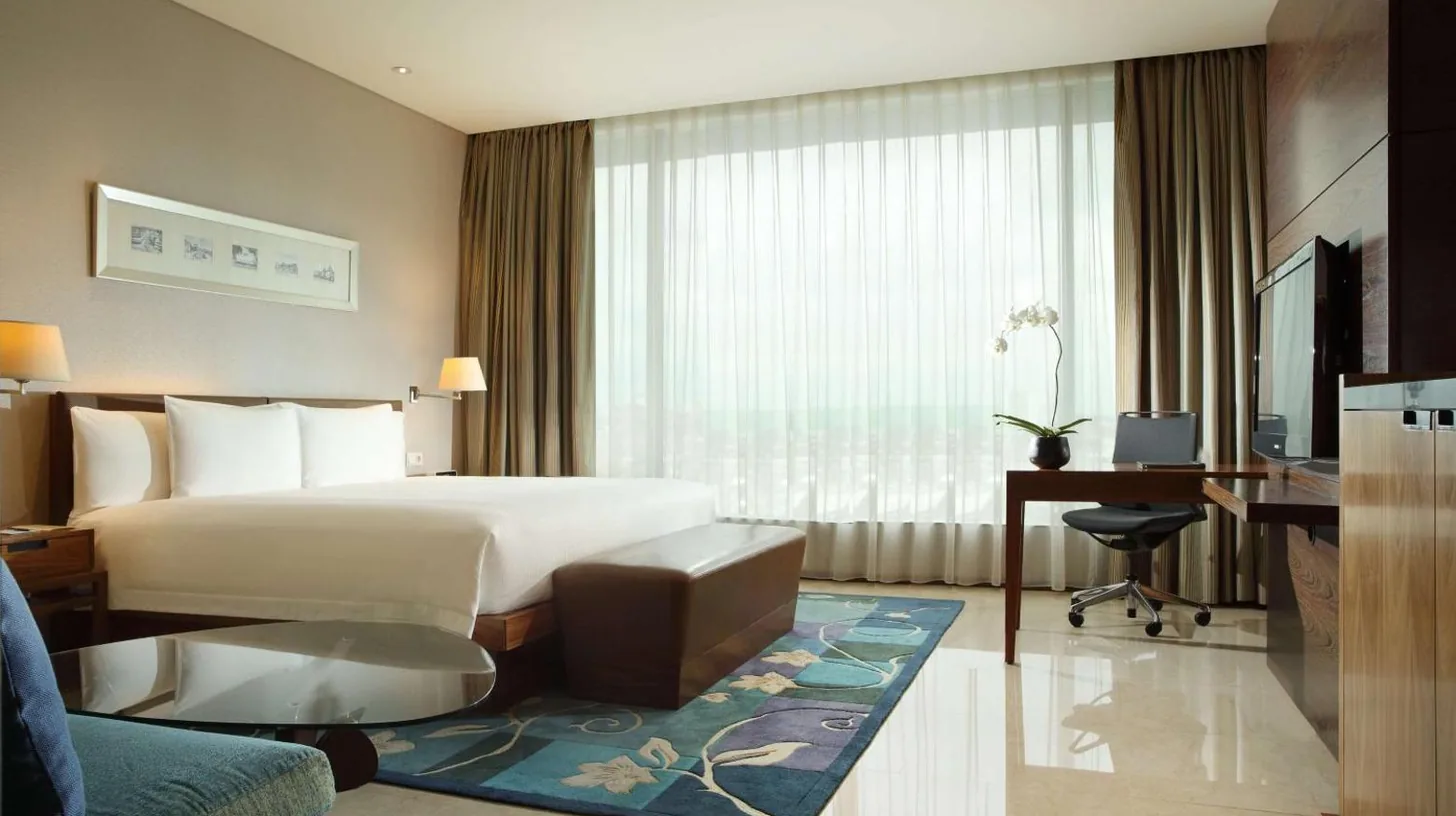 a bathroom with a tub and a sink and a mirror at Hilton Bandung in Bandung