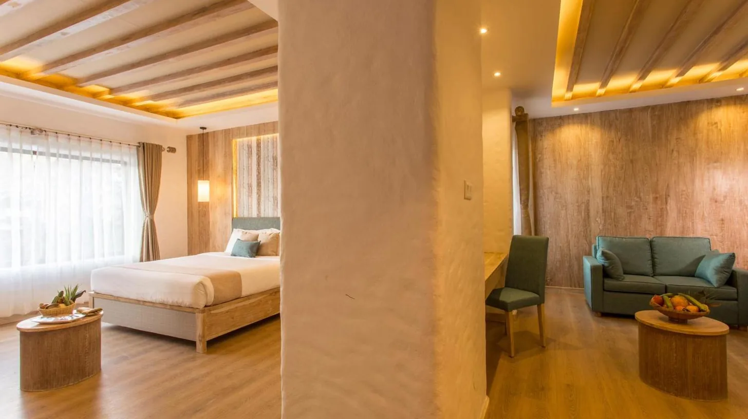 una sala de estar con dos sofÃ¡s verdes y una mesa en el Hotel Barahi Pokhara en Pokhara