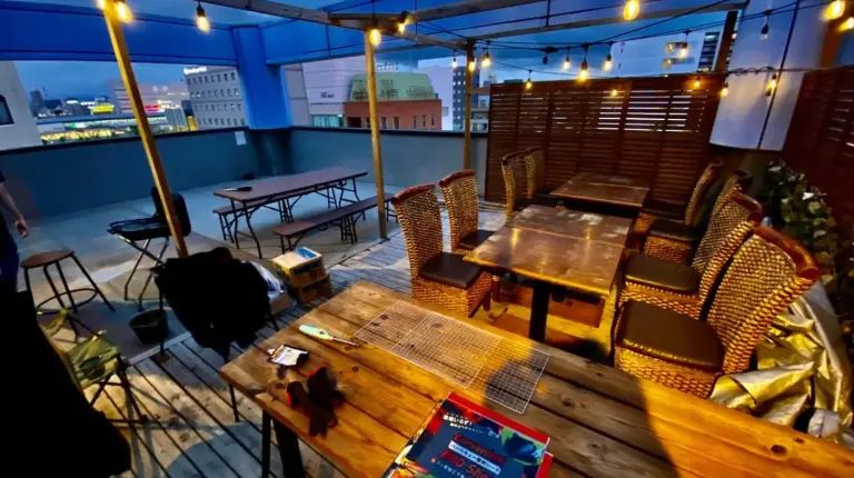 a table and chairs on a balcony with lights at Hotel EL Utsunomiya 7 free parking in Utsunomiya